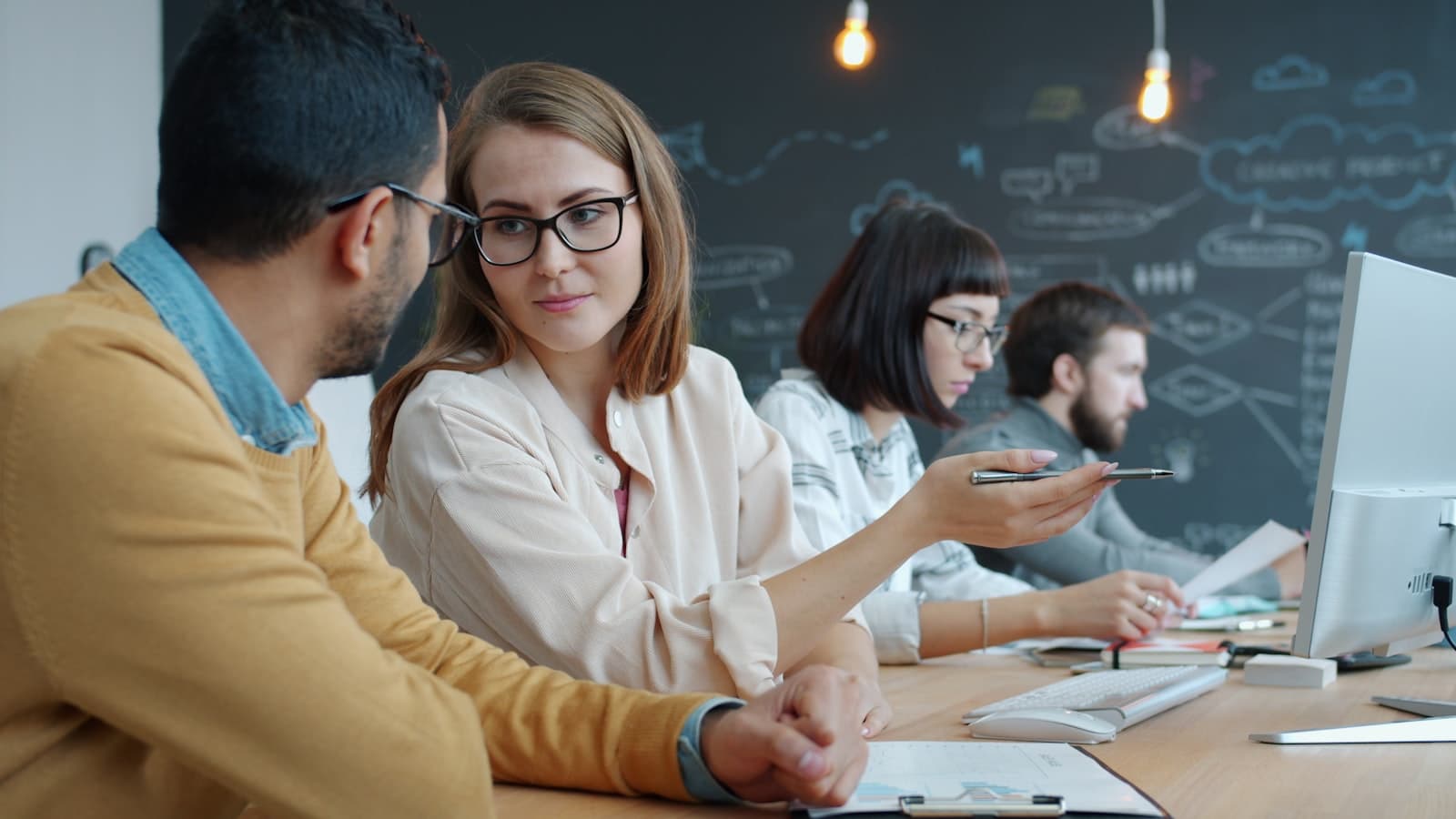 Colleagues collaborating at a modern office desk