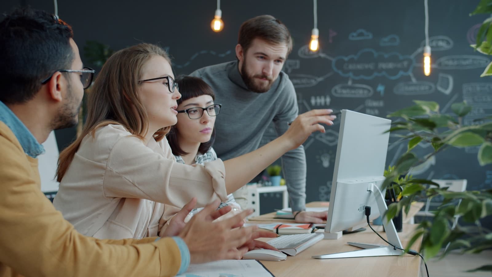 Team collaborating around a computer in an office